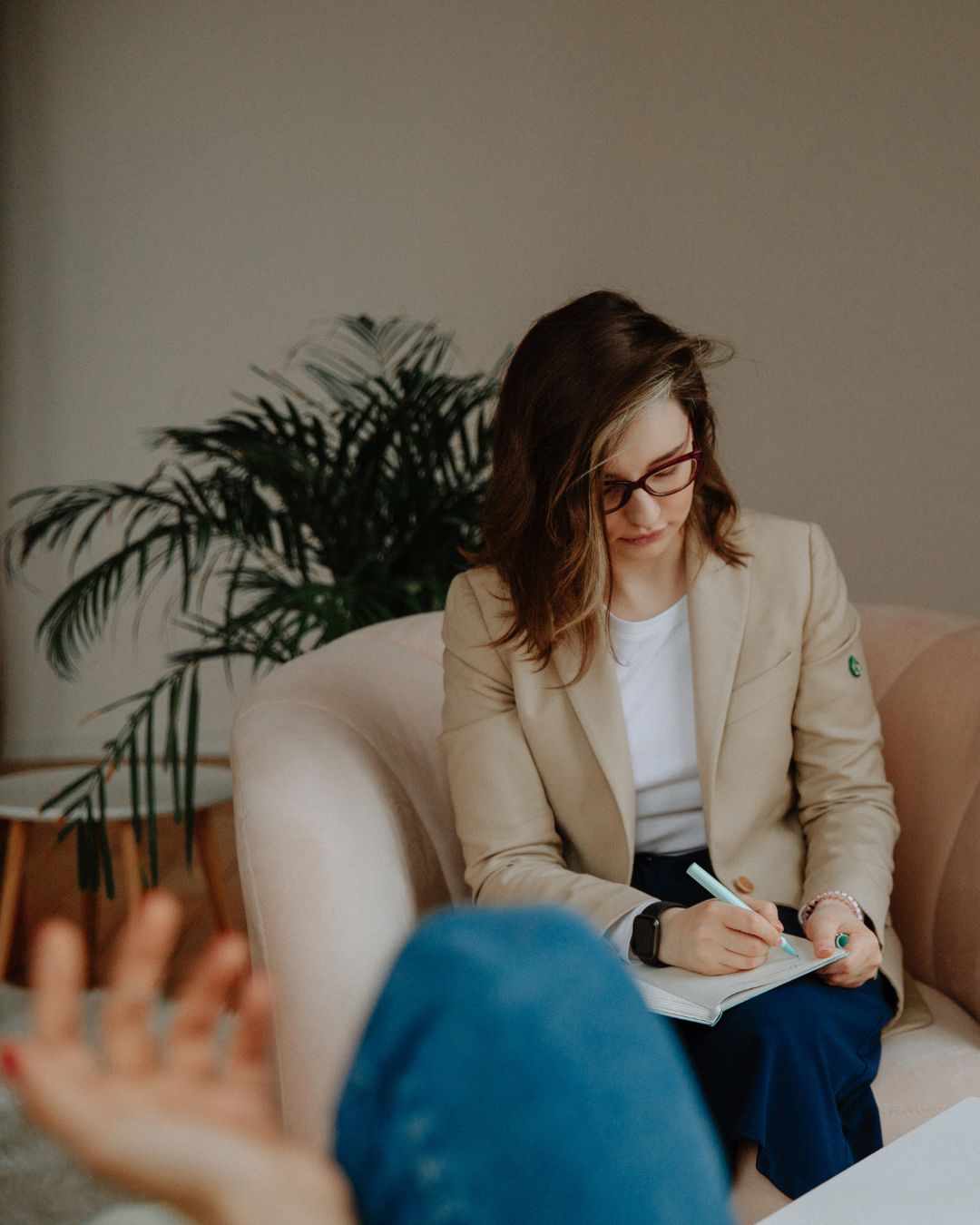 Holistic therapist taking notes during a personalized therapy session